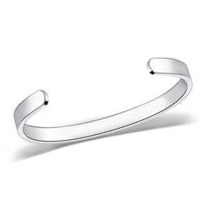 Macro detail of polished stainless steel C-shaped cuff bracelet with a shiny silver finish