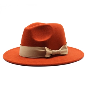 Close-up of wool fedora hat with a flat brim and champagne gold satin ribbon bow