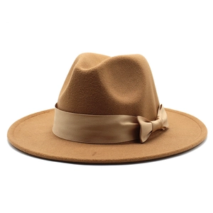 Detail of camel wool fedora hat featuring a satin ribbon band and elegant flat bow tie