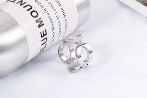 Nahaufnahme eines silbernen hohl-geometrischen Rings auf weißer strukturierter Fläche