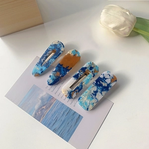 Detail view of blue marble acrylic hair clips with metal base in minimalist INS style