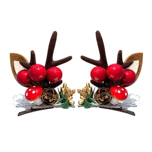 Cute Christmas reindeer antler hair clips with red berries and pine cones on white background