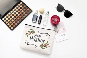 Detailed view of white canvas cosmetic bag with 'BEST Wishes' print and zipper closure