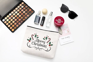 Flat lay of a cotton linen Christmas makeup bag with festive Merry Christmas print
