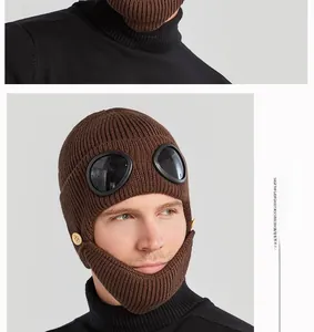 Detail of dark brown knitted pilot hat with integrated goggles and warm face mask