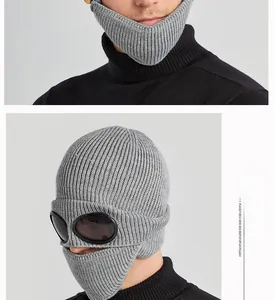 Detail of grey knitted goggle beanie with integrated black windproof lenses for skiing