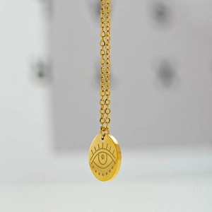 Golden stainless steel necklace featuring a sunburst evil eye engraved round pendant charm