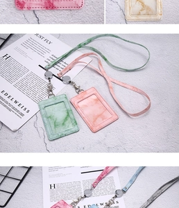 Close-up of marble texture ID card holder with pink and green lanyard and retractable badge reel