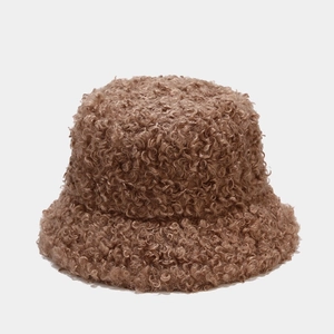 Dettaglio della trama in pile teddy marrone su un cappello a secchiello invernale