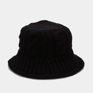 Detailed view of the thick cable knit texture on a black winter bucket hat for women