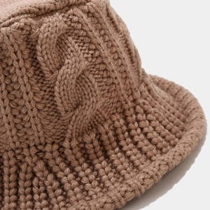 Detailed close-up of thick cable knit pattern on brown bucket hat with wool texture