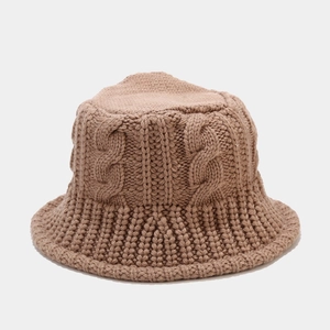 Close-up of thick cable knit texture on a brown bucket hat made of warm wool yarn