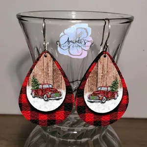 Detail of teardrop leather earrings with red truck and Christmas tree print patterns
