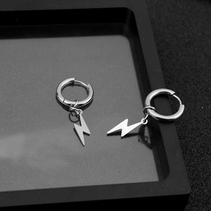 Macro shot of polished stainless steel lightning bolt earrings on a black display tray