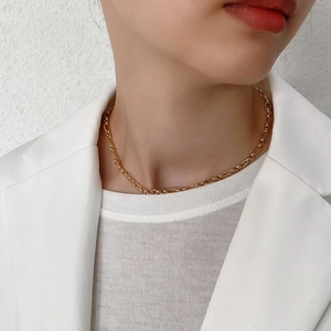 Detailed view of bold gold 925 sterling silver chain choker on a fashion model