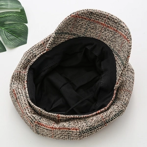 Detail view of khaki plaid newsboy hat interior featuring adjustable black inner strap
