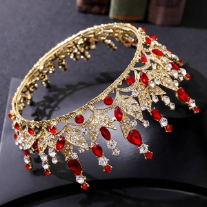 Detailed close-up of golden crown with red rhinestones and leaf motifs on black stand