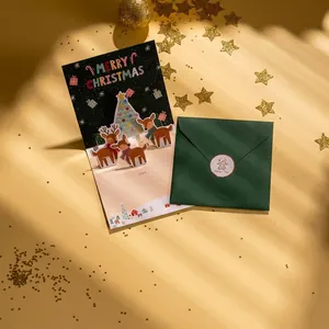 Carte de Noël 3D avec renne et sapins sur fond étoilé et enveloppe vert foncé