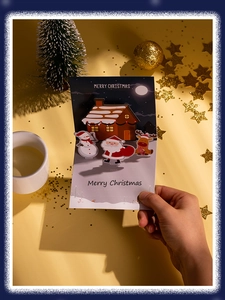 Gros plan d'une carte de Noël 3D avec Père Noël et renne tenue à la main