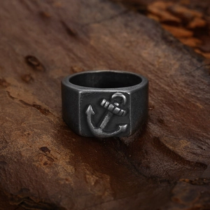 Vintage stainless steel anchor ring for men with antique silver finish on wood background