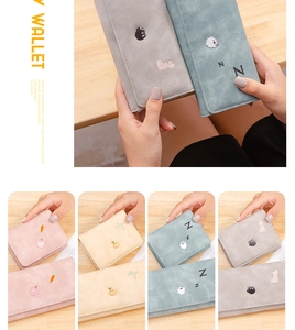 Detailed grid of macaron-colored short wallets with cute embroidery on matte texture