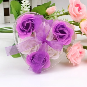 Macro view of heart-shaped gift box with 6 purple and white soap roses and ribbon