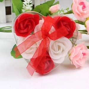 Detailed view of heart-shaped gift box with red and white soap roses and organza bow