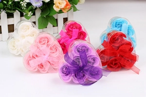 Macro detail of heart-shaped gift boxes with three scented soap roses and satin bows