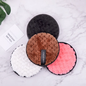 Macro view of four round microfiber makeup remover pads in black, white, pink, and brown