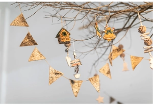 Detail of natural birch bark pennants and wooden gingerbread ornaments on winter branches