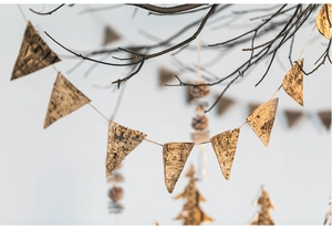 Close-up of natural birch bark triangle bunting hanging on a branch for Christmas decor