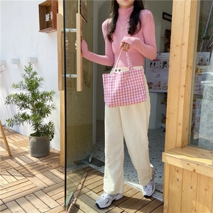 Pink knit sweater and corduroy wide-leg pants styled with a plaid canvas handbag