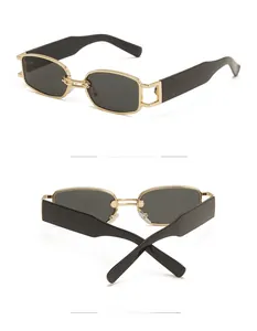Detail view of retro narrow rectangle sunglasses with gold metal frame and black temple arms
