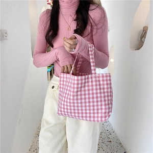Detail of hand-held pink checkered cotton linen tote bag with soft double handles