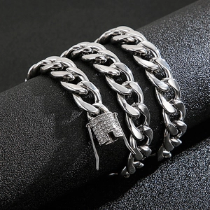 Detail of silver Cuban link chain with crystal encrusted buckle on a textured black stand