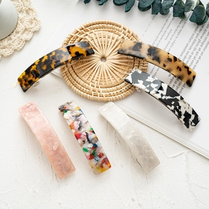 Detailed flat lay of six acetate spring hair clips with marble and tortoise patterns
