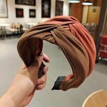 Detail eines breiten geknoteten Stoff-Haarreifs in Braun und Orange mit weichem Material