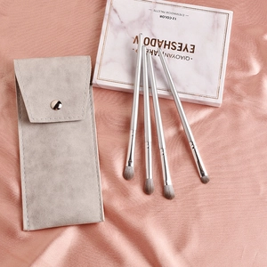 Détail de 4 pinceaux à paupières à manche argenté et une pochette de rangement grise