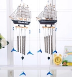 Détail de carillons à vent voilier en bois avec tubes en métal et pendentifs dauphins