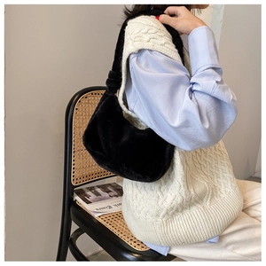 Side view of a soft black plush hobo bag worn as a trendy underarm shoulder bag