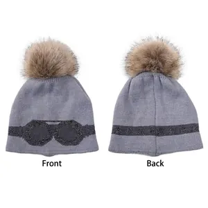 Gray knit beanie with fur pom pom featuring sequin goggles and star pattern