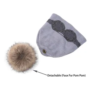 Purple knitted beanie with sequined goggles pattern and detachable faux fur pom-pom