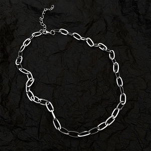Minimalist silver oval link chain necklace with lobster clasp on black textured background