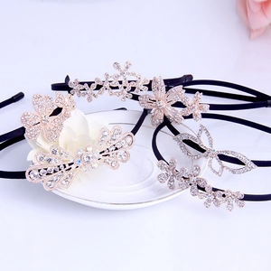 Detailed view of five black rhinestone headbands with flower and butterfly motifs on a plate