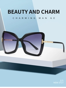 Detail of golden T-shaped metal logo on butterfly frame sunglasses with purple lenses