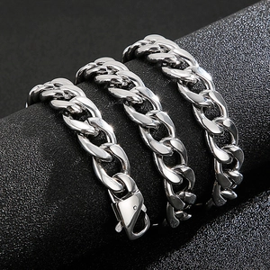 Macro detail of silver-tone cuban link bracelet with polished finish and lobster clasp