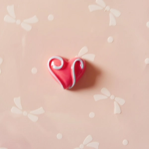 Macro detail of heart-shaped pink resin charm with blue 3D swirl texture for DIY crafts