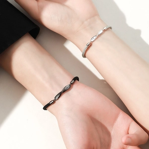 Minimalist Mobius silver couple bracelets with black and silver braided cords worn on wrists
