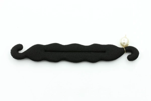 Detail of black sponge hair bun maker with wavy design and elegant white pearl accent