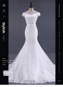 Dettaglio dell'abito da sposa a sirena con ricami in pizzo e paillettes su tessuto bianco brillante